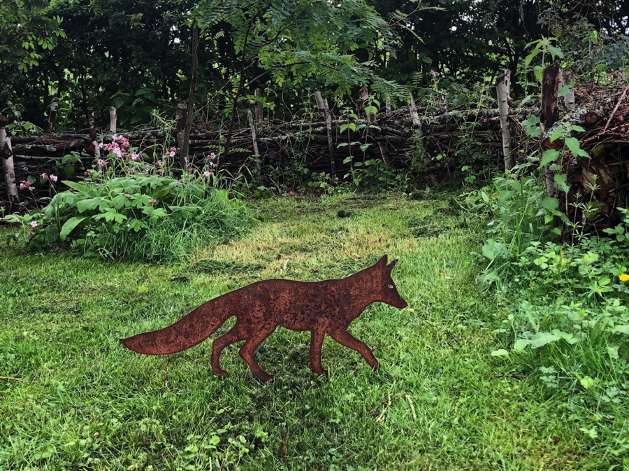 Walking fox decoration on green grass